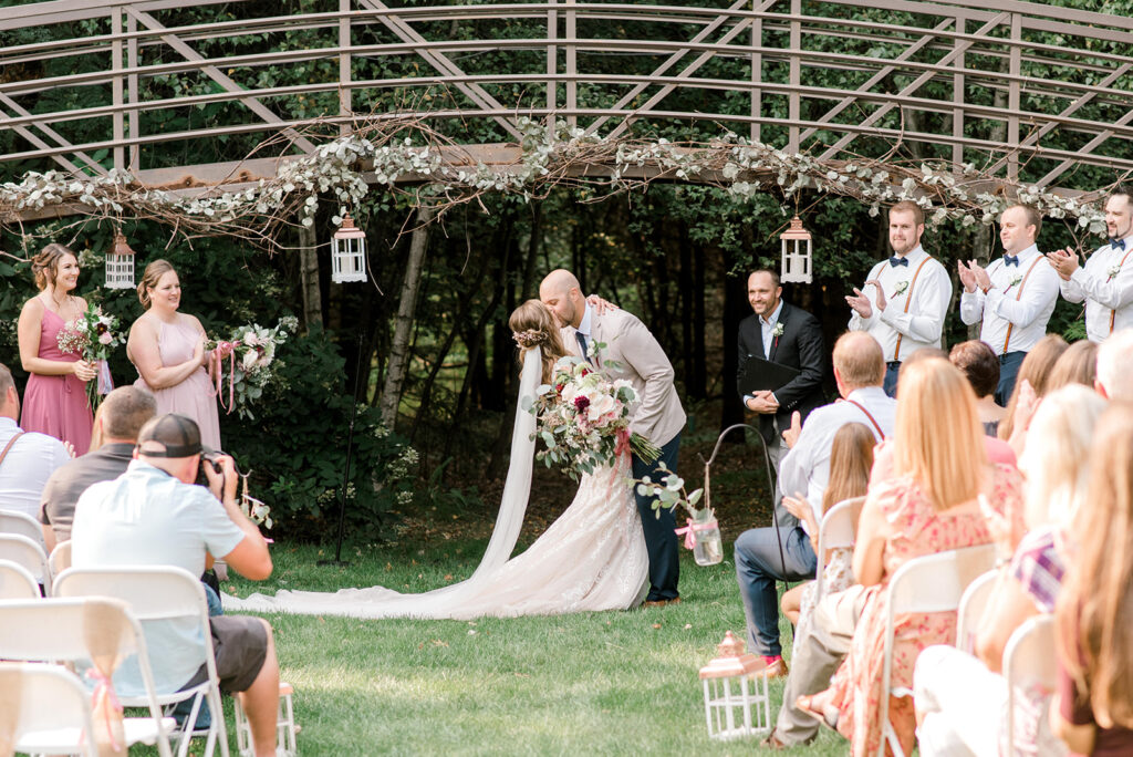 a Couple's first kiss at a white's wildwood retreat wedding