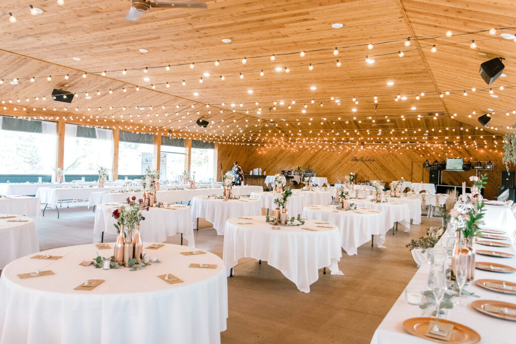 The pavilion at white's wildwood retreat with white tablecloths and decorations