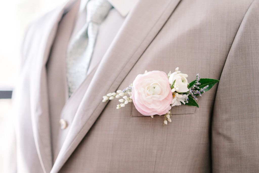 Groom with pink floral pocket boutonniere for a spring wedding in Wisconsin